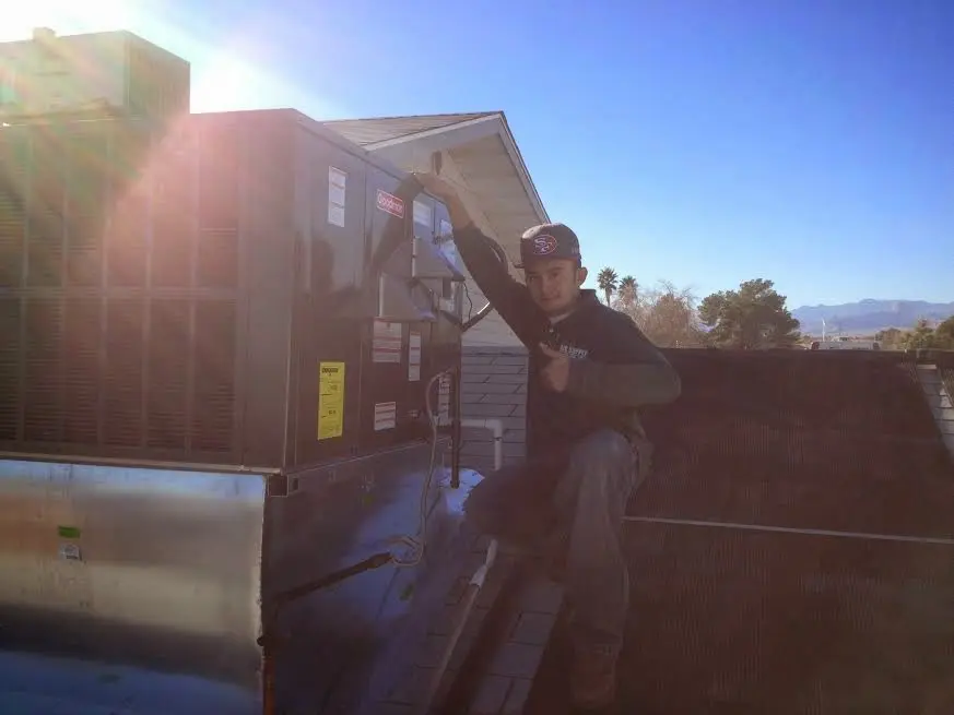 HVAC technician performing AC Tune-Up on a rooftop unit in Hillsdale