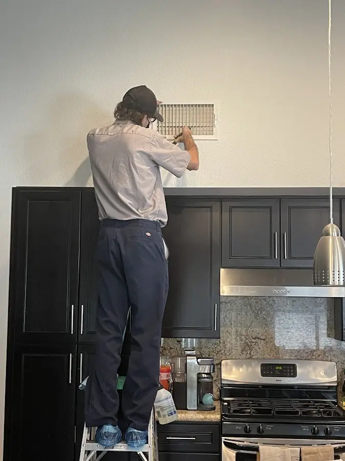 Technician inspecting an air vent during HVAC service in Hillsdale